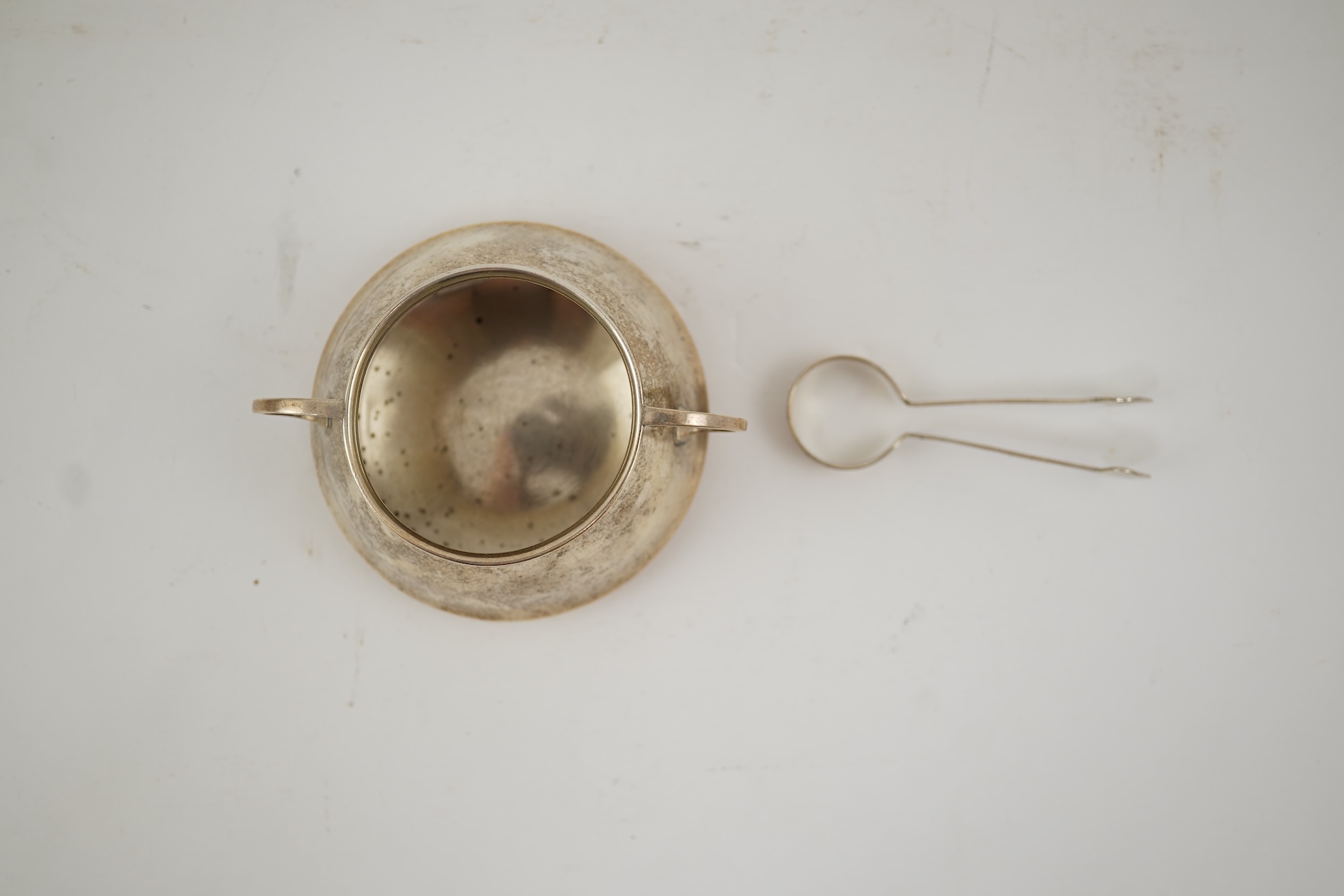 An Edwardian silver bachelor's two handled sugar bowl and matching sugar tongs, by Liberty & Co